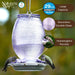 Hummingbird feeder with features highlighted on a blurred natural background