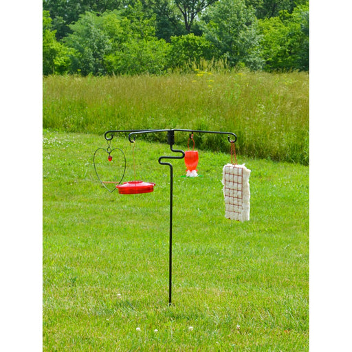 Bird feeder stand with multiple bird feeders on a grassy field