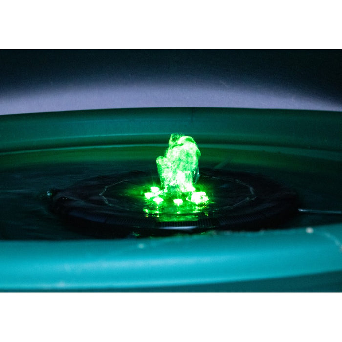 Green glowing object floating on water with a dark background