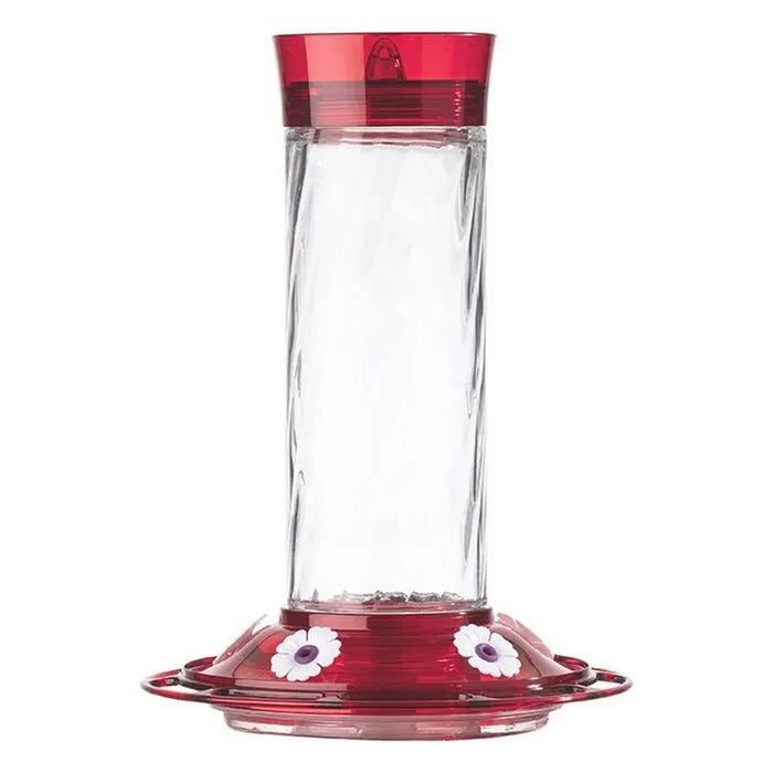 Clear hummingbird feeder with red top and bottom on a white background