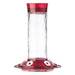 Clear hummingbird feeder with red top and bottom on a white background