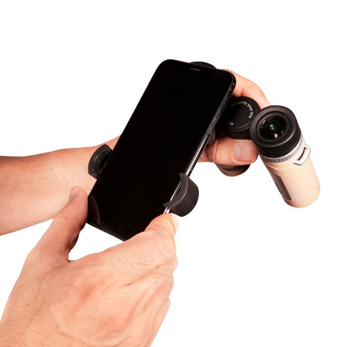 Hand holding a smartphone with a phone holder attached, using a binocular attachment on a white background