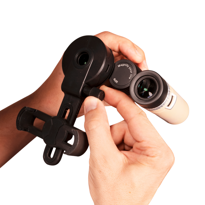 Hand holding a pair of binoculars with a white background