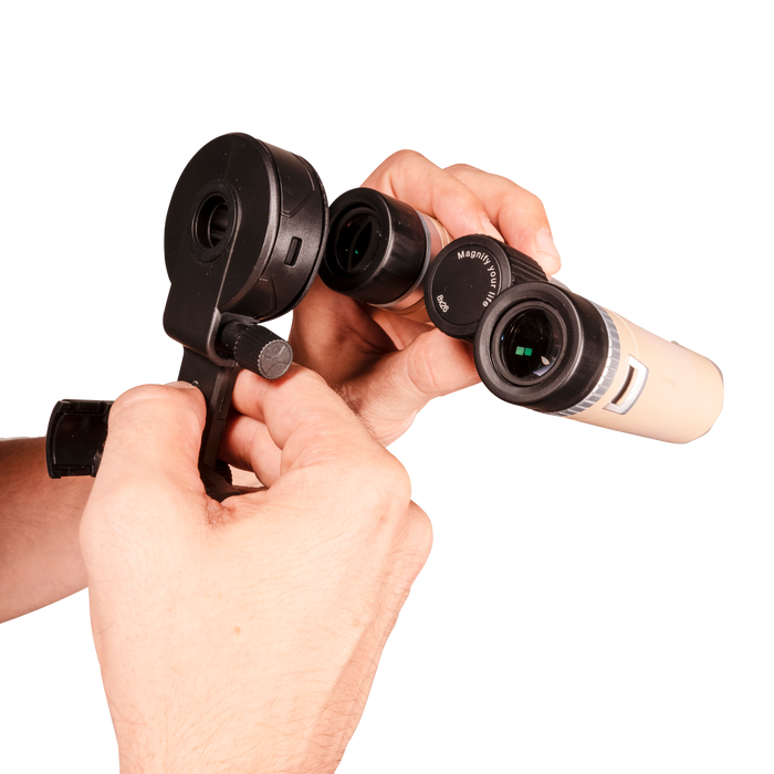 Hand holding a pair of binoculars with a white background