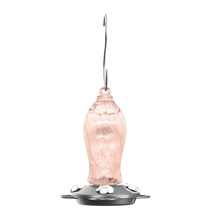 Pink glass hummingbird feeder with metal hook on a white background