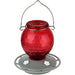 Red glass hummingbird feeder with metal hook on a white background