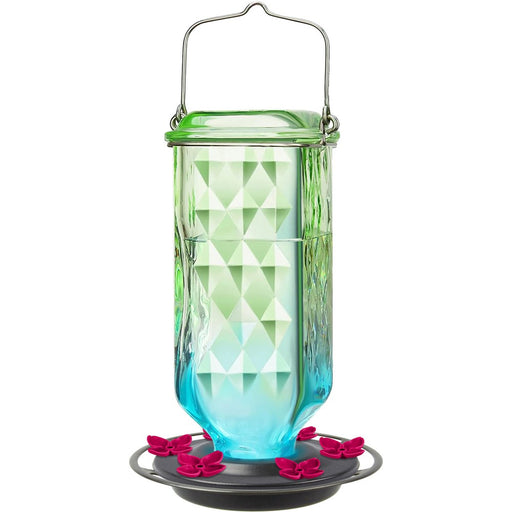 Glass hummingbird feeder with geometric design on a white background