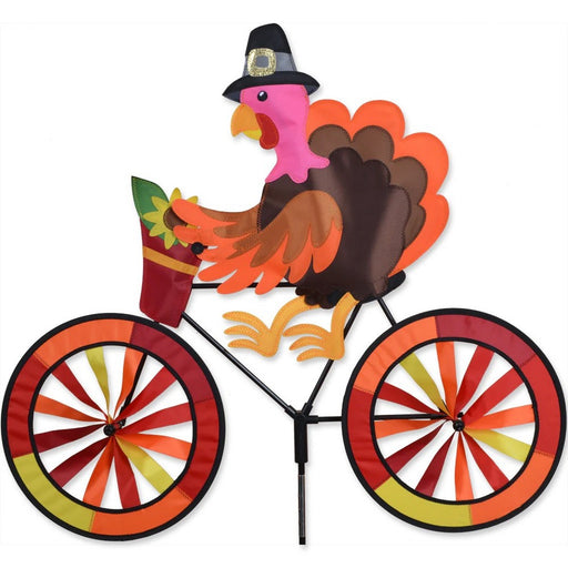 Colorful turkey on a bicycle windmill with a white background