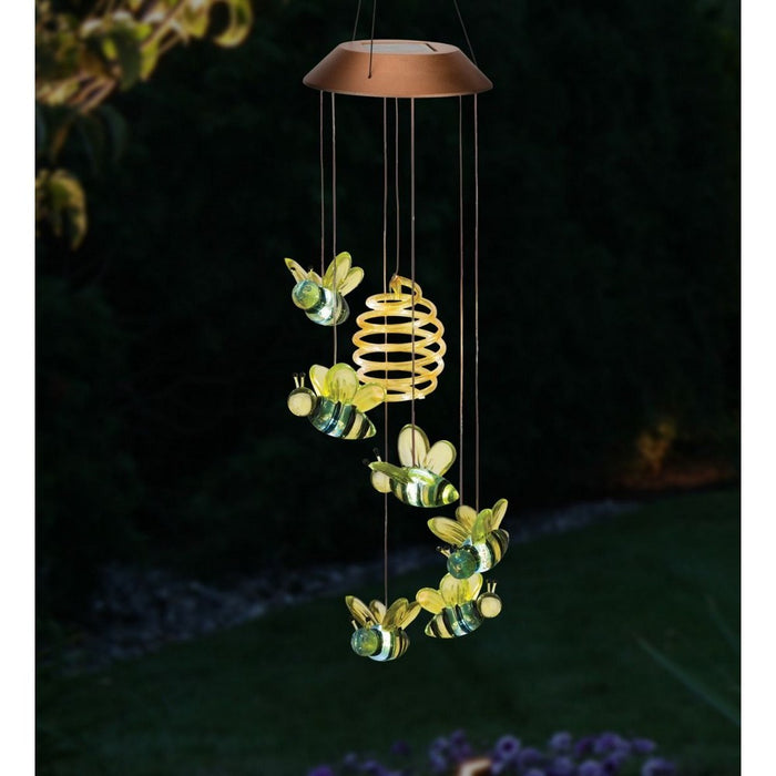 Solar-powered hanging lamp with bee design in a garden setting