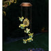 Solar-powered hanging lamp with bee design in a garden setting