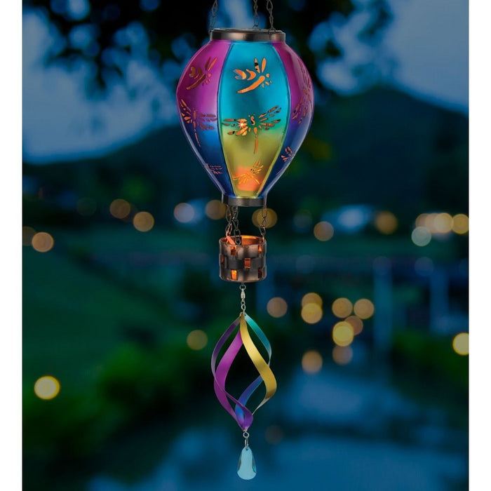 Colorful wind chime with dragonfly design against a blurred outdoor background