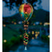 Colorful hanging lantern with a spiral design against a blurred outdoor background