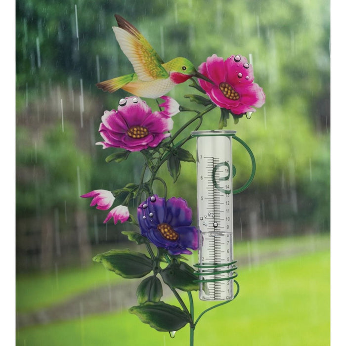 Decorative rain gauge with flowers and a hummingbird on a rainy day background