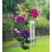 Decorative rain gauge with flowers and a hummingbird on a rainy day background