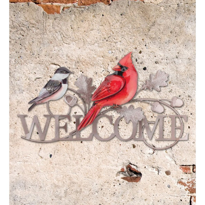 Decorative metal sign with two birds and 'Welcome' text on a textured wall.