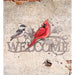 Decorative metal sign with two birds and 'Welcome' text on a textured wall.