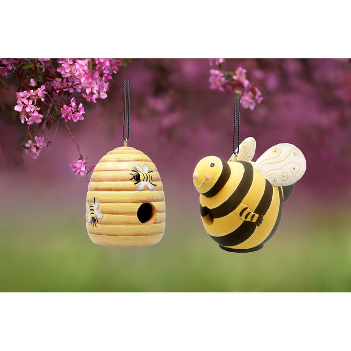 Hanging bee-shaped birdhouse and bee ornament with a blurred floral background