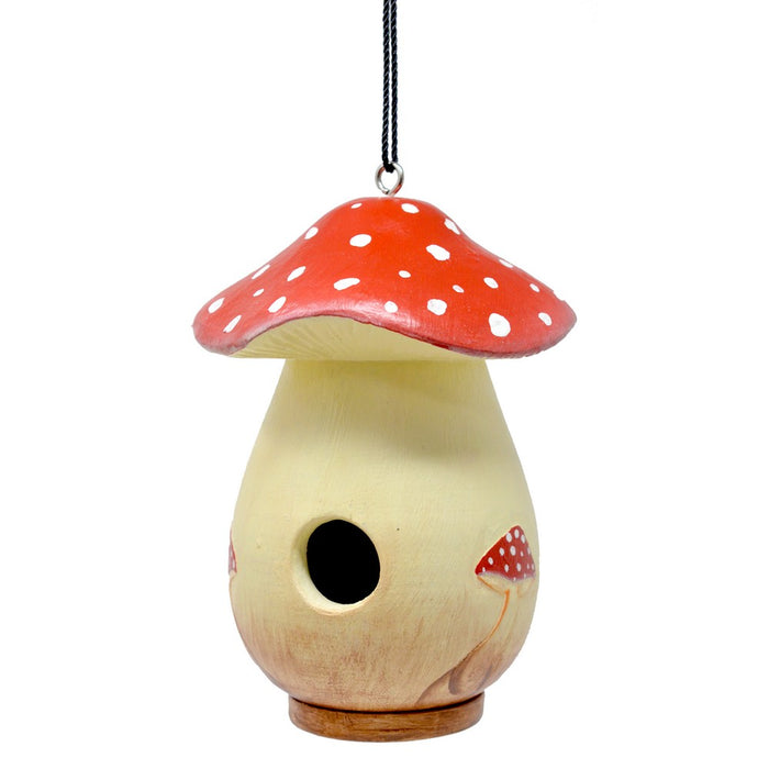 Wooden birdhouse shaped like a mushroom with a red cap on a white background
