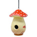 Wooden birdhouse shaped like a mushroom with a red cap on a white background