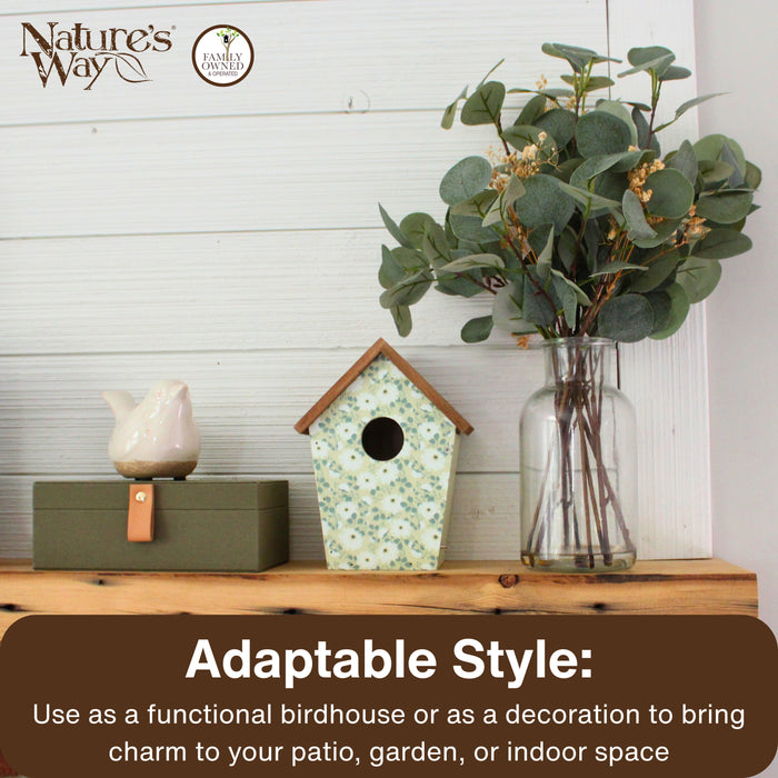 Decorative birdhouse, bird figurine, and vase with greenery on a wooden surface with 'Nature's Way' branding.