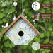Decorative birdhouse with floral pattern hanging against a green leafy background, featuring Nature's Way branding.