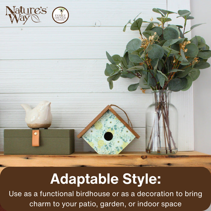 Decorative birdhouse, bird figurine, and vase with greenery on a wooden surface with 'Nature's Way' branding.