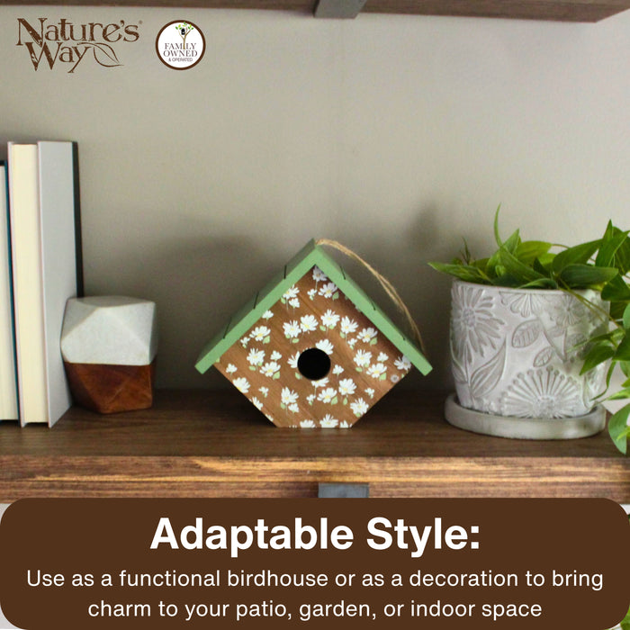 Decorative birdhouse on a shelf with plants and books, featuring Nature's Way branding.