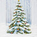 A festive Christmas greeting card featuring a snow-covered evergreen tree with ornaments, set against a snowy winter forest scene with the text 'Merry Christmas' at the bottom.